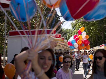 Unas animadoras infantiles regalan globos a los niños durante la Feria del Libro de Madrid.