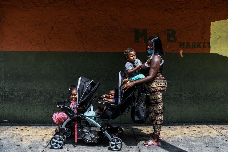 Una mujer posa junto a sus tres hijos en un barrio afroamericano de Miami (EE UU).