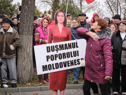 Una mujer golpea una figura de cartón de la presidenta de Moldavia, Maia Sandu, durante una protesta iniciada por el populista Partido Sor, en Chisinau el día 13.