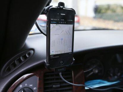 Un m&oacute;vil instalado en un coche muestra la aplicaci&oacute;n de Uber 