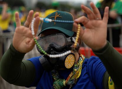 Un partidario del ex presidente de extrema derecha de Brasil, Jair Bolsonaro, muestra un rosario durante las protestas, en Brasilia.