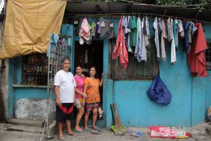 Nico Espinosa, presidente de la Asociación de vecinos de Valenzuela (Manila, Filipinas), posa con la familia delante de su tienda.