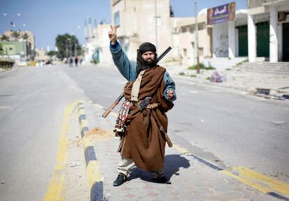 Un residente de Zawiya (50 kilómetros al oeste de Tripoli), que forma parte del levantamiento contra Gadafi, empuña sus armas en medio de la calle de la ciudad.