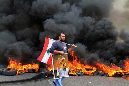 Un manifestante porta un cartel con el rostro del primer ministro saliente Saad Hariri y una bandera de Líbano durante las prostestas en la ciudad de Sidón, al sur del país.