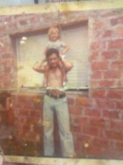 Luis Ceccón plays with his son Silvio, in front of a house.