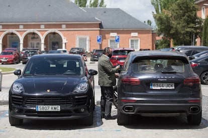 Un hombre, entre dos 'porsches' en La Moraleja.