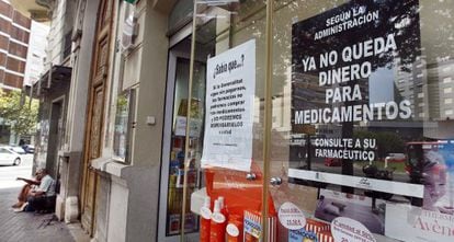 Escarapate de una farmacia en el centro de la ciudad de Valencia en el que se muestra un cartel contra los impagos