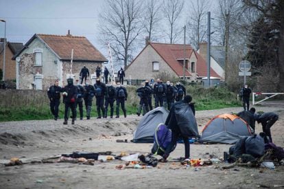 Agentes de policía sacan a migrantes de un campamento en Calais (Francia) el 28 de noviembre