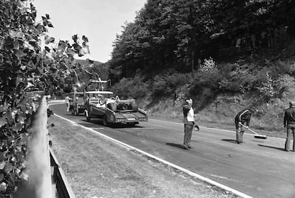 Unos operarios limpian la pista de Nürburgring y retiran el Hesketh tras el accidente de Lauda.  / HANS PETER (AP)