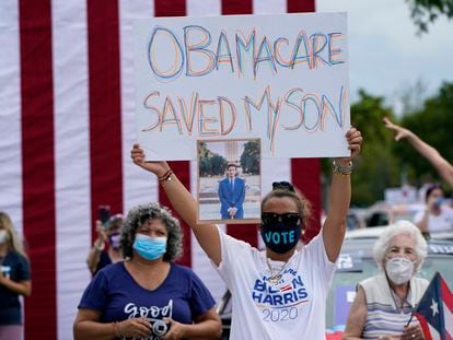 Una persona sostiene una pancarta en la que se lee "Obamacare salvó a mi hijo" en un evento de campaña de Joe Biden en Miami en 2020.