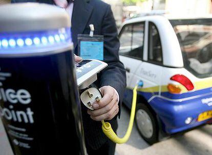 Un conductor conecta el enchufe de su coche eléctrico a un poste de recarga en el centro de Londres. El servicio cuesta 100 euros al año.
