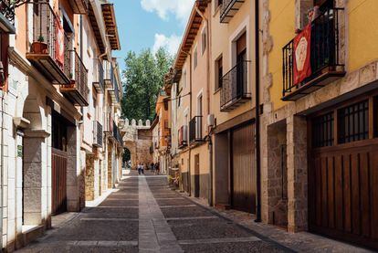 Una de las calles de esta localidad de la comarca de la Alcarria en las que se puede ver, al fondo, una de las puertas de la muralla.