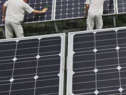 Un grupo de trabajadores chinos limpia unos paneles solares en Hebei, China.