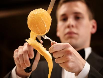 Un profesional de sala pela una naranja al estilo del restaurante Via Veneto, en Barcelona. Imagen proporcionada por el local.