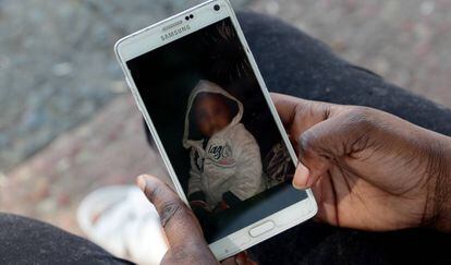 Oumo muestra una foto de su hijo en el móvil.