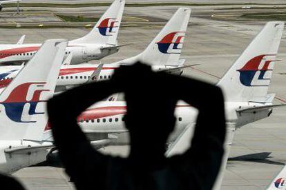 Un hombre mira un avi&oacute;n de Malaysia Airlines en el aeropuerto de Kuala Lumpur, el pasado 25 de febrero.