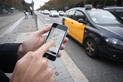 Un vianant sol·licita un cotxe a través d'Uber a la Diagonal de Barcelona.