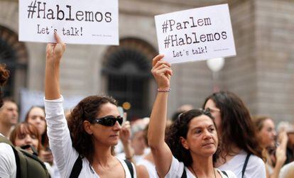 Dos mujeres sostienen carteles a favor del di&aacute;logo este s&aacute;bado en Barcelona.