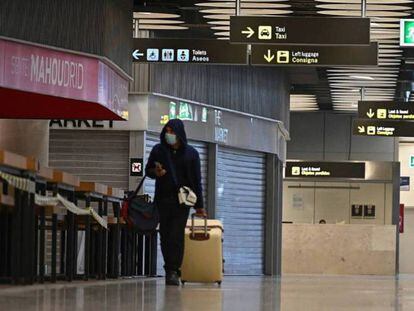 Un viajero transita por el aeropuerto de Barajas con tiendas y bares cerrados durante el estado de alarma.