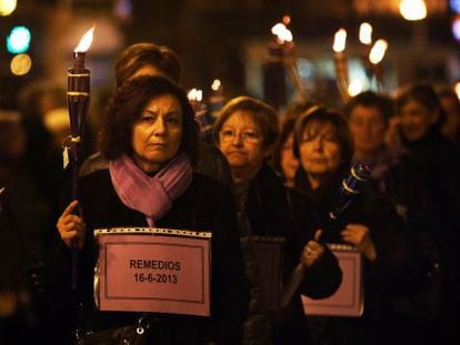 Un grupo de mujeres porta 77 antorchas y esquelas en recuerdo de las v&iacute;ctimas de violencia de g&eacute;nero en 2013 en Espa&ntilde;a.