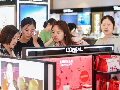 Turistas compran productos de L'Oreal en un duty free de la provincia china de Hainan.