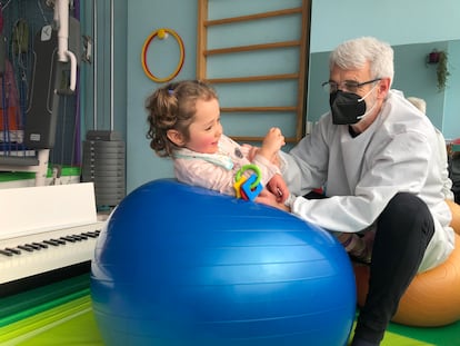 Una niña que padece una enfermedad rara hace un ejercicio con su fisioterapeuta, en Madrid.