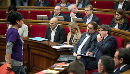 Anna Gabriel, diputada de la CUP, passa davant de Puigdemont al Parlament.