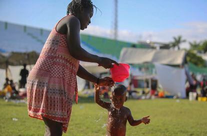 Una mujer baña a un niño en un campamento para personas desplazadas por el terremoto en Los Cayos, Haití, el pasado domingo 15 de agosto.