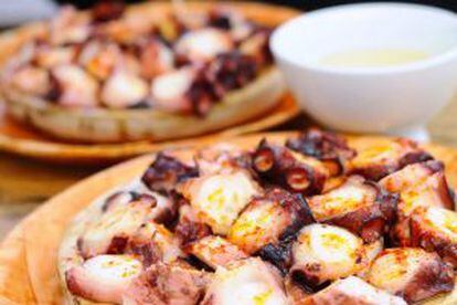 Pulpo a feira is served on a round wooden plate.