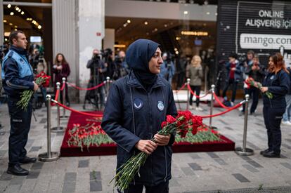Una policía municipal sostenía este lunes unas flores junto al lugar que rinde tributo a las víctimas del atentado en una calle céntrica de Estambul.