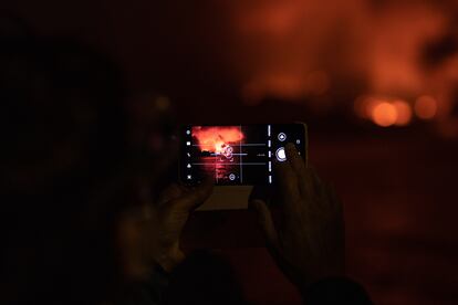 Un turista toma una fotografía de la erupción desde el mar.