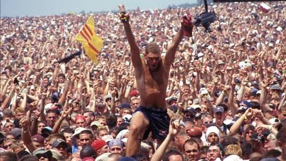 Un hombre se alza sobre la multitud que atestó el festival Woodstock, en Rome (Nueva York) en julio de 1999.