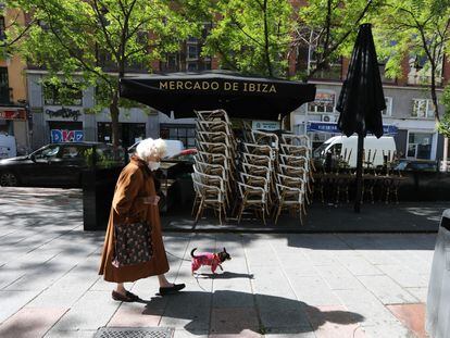 Una mujer pasa junto a una terraza cerrada de un bar en Madrid.