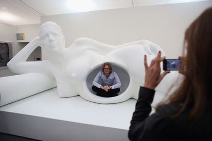 Un visitante de la feria de arte Frieze es fotografiado en una escultura de Jennifer Rubell.