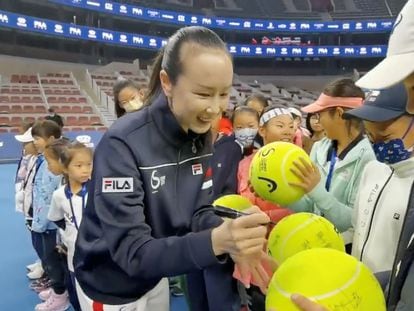 La tenista china Peng Shuai firma unas pelotas de tenis en un torneo juvenil en el que reapareció en Pekín el 21 de noviembre.