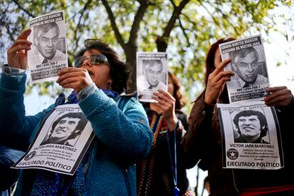 Miembros de la Comisión Funa sostienen fotografías de Edwin Dimter Bianchi y Víctor Jara durante una protesta en 2017.. 