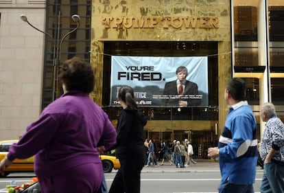 Peatones pasan en 2004 delante de un cartel del programa de Donald Trump El aprendiz, colgado de la Trump Tower, de su propiedad, en Nueva York. 