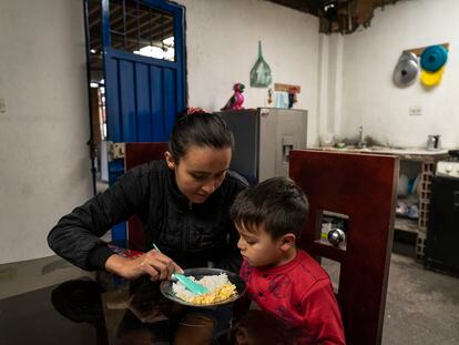 Andrea Usma acompaña a su hijo de cuatro años a la hora de la cena, en el barrio de Patio Bonito, al sur de Bogotá.