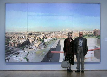 Antonio López y su esposa, frente a una de las obras más conocidas del artista, "Madrid desde Vallecas", pintada entre 1997 y 2006.