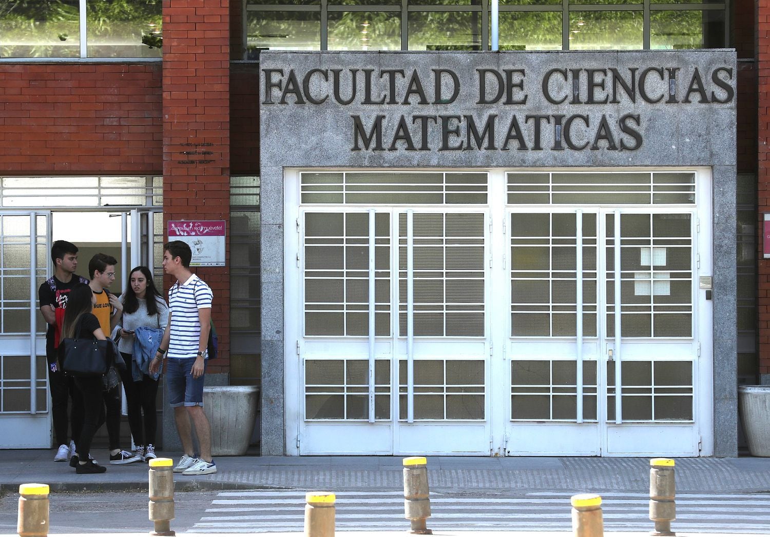 Un grupo de jóvenes, en las puertas de la Facultad de Ciencias Matemáticas de la Universidad Complutense, en mayo de 2019.