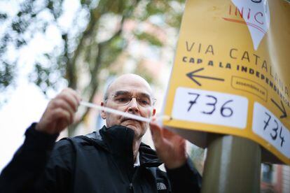 Un voluntario coloca carteles en Ciutat Vella.