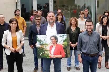 Oriol Junqueras (ERC) sostiene una imagen de su compañera de partido Marta Rovira acompañado a su derecha de la portavoz Marta Vilalta y del presidente de la Generalitat, Pere Aragonès.