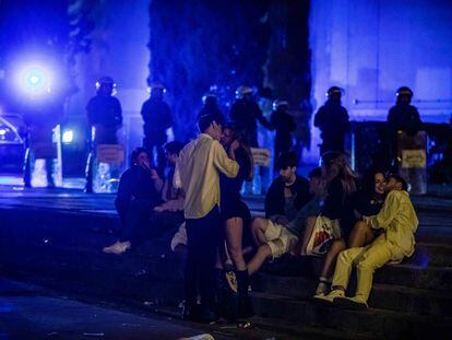 Jóvenes en las escaleras de la plaza de Espanya mientras la Guardia Urbana desaloja la zona en la última madrugada de las fiestas de La Mercè.