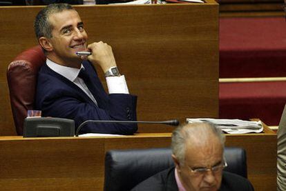 Ricardo Costa sonríe en su escaño de las Cortes, justo detrás del consejero Rafael Blasco.
