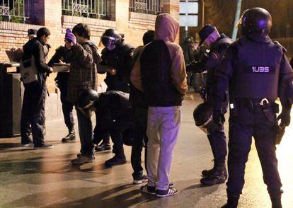 La policía cachea y toma los datos a un grupo de manifestantes en una céntrica calle de Madrid.