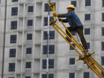 Un obrero trabaja sobre un andamio para encofrado en las obras de construcción de un edificio. EFE/Archivo