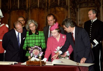 La reina Isabel de Inglaterra firma en el libro de honor en el Ayuntamiento de Barcelona, acompañada del duque de Edimburgo (a la izquierda), los Reyes de España y el alcalde de Barcelona, Pascual Maragall (a la derecha), dentro de los actos de su visita oficial a España en octubre de 1988.