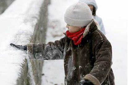 Dos niños juegan con la nieve en un parque de Pamplona.