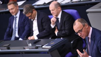El líder de la oposición alemana, el conservador Friedrich Merz, durante su intervención este martes en el Bundestag, con el canciller Olaf Scholz y los ministros Robert Habeck (centro) y Christian Lindner escuchándole en sus escaños.