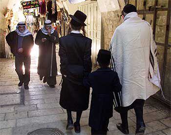 Un judío ultraortodoxo y sus dos hijos se cruzan en la ciudad vieja de Jerusalén con dos palestinos.
